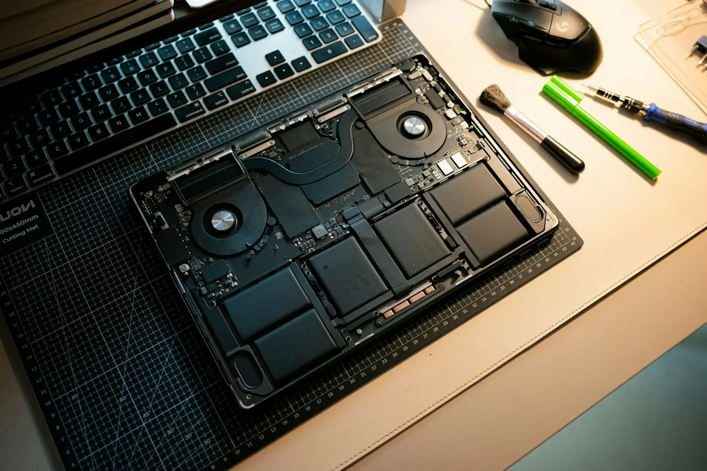 Notebook aberto sobre uma base de corte, com os componentes internos expostos para manutenção